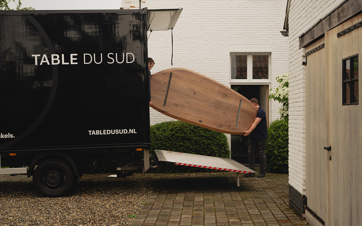 Uitladen van Table du Sud bus bij de bezorgservice van de meubels