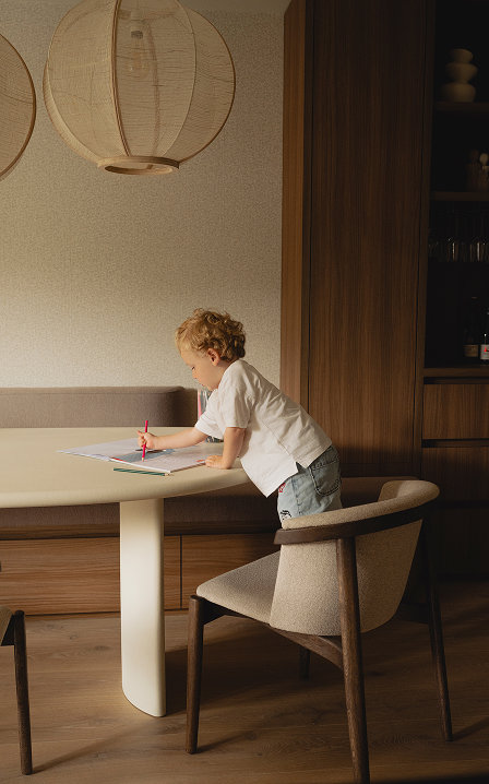 Kind aan het tekenen aan betonlook eettafel van Table du Sud