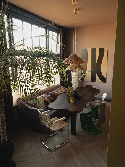 Kleurrijk klassiek interieur voor de woontrends van 2027. Organische eettafel met eetkamerstoelen en een eetkamerbank