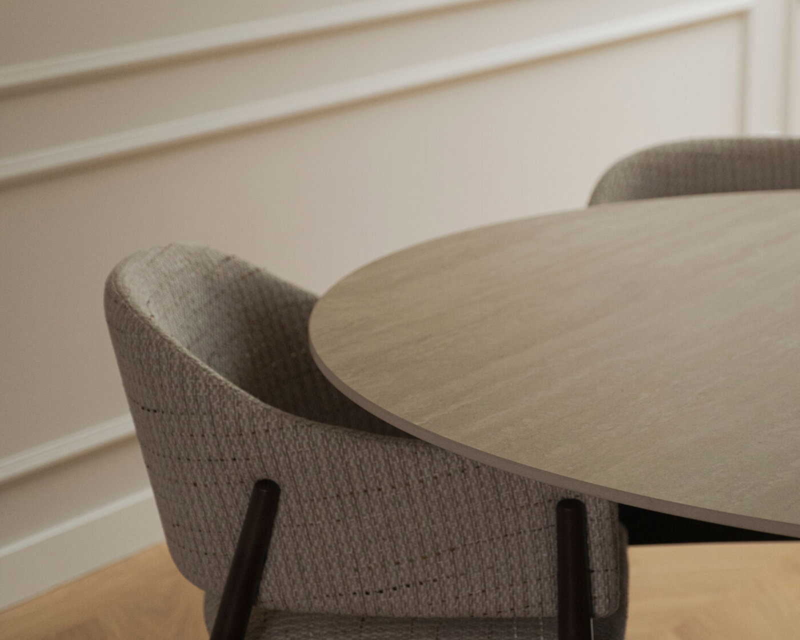 Ronde keramische eettafel Qone oak met een stoffen eetkamerstoel
